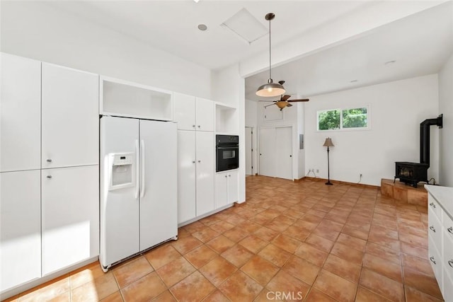 kitchen featuring decorative light fixtures, white refrigerator with ice dispenser, beam ceiling, oven, and white cabinets