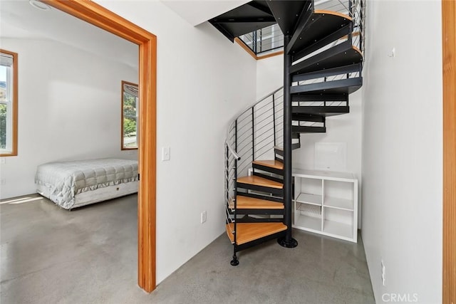 staircase featuring concrete floors