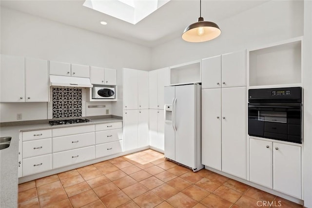 kitchen featuring pendant lighting, black oven, white cabinets, white fridge with ice dispenser, and light tile patterned floors