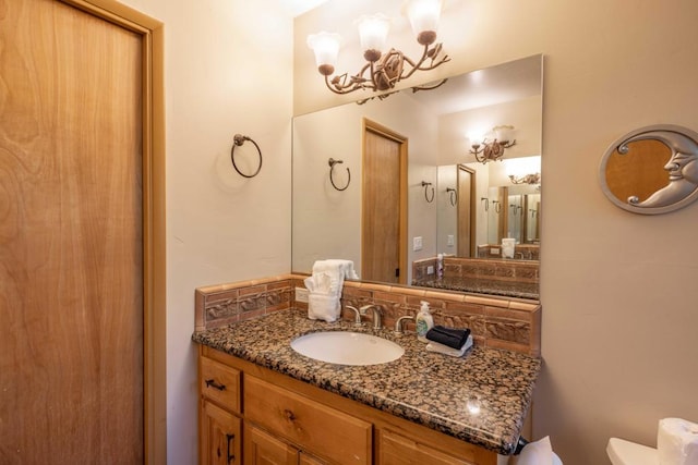 bathroom featuring vanity, toilet, and decorative backsplash