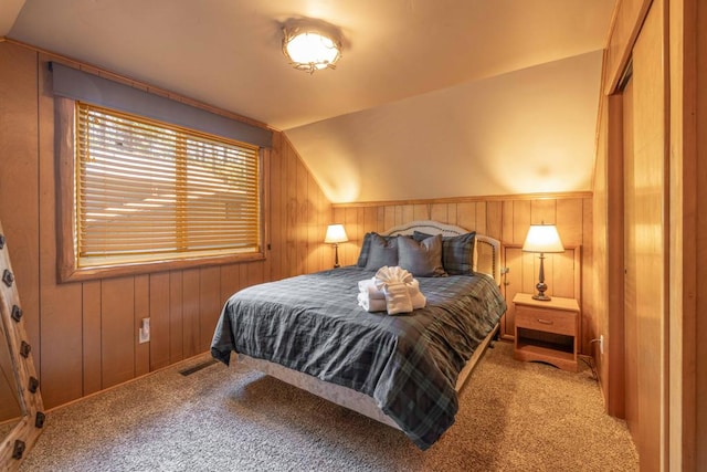 carpeted bedroom featuring lofted ceiling and wood walls