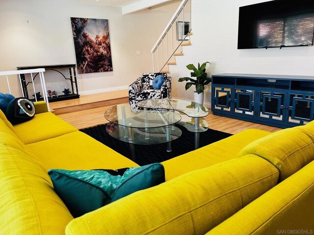 living room with beam ceiling and wood-type flooring