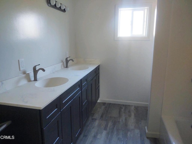 bathroom featuring a tub, hardwood / wood-style floors, and vanity