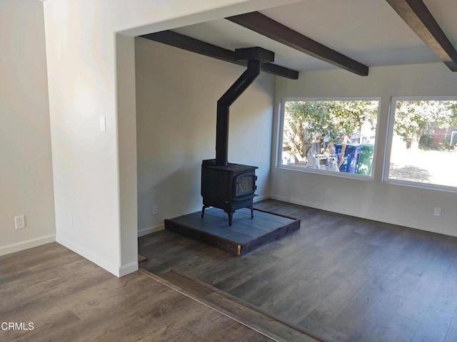 living room featuring a wood stove, dark hardwood / wood-style flooring, and beam ceiling