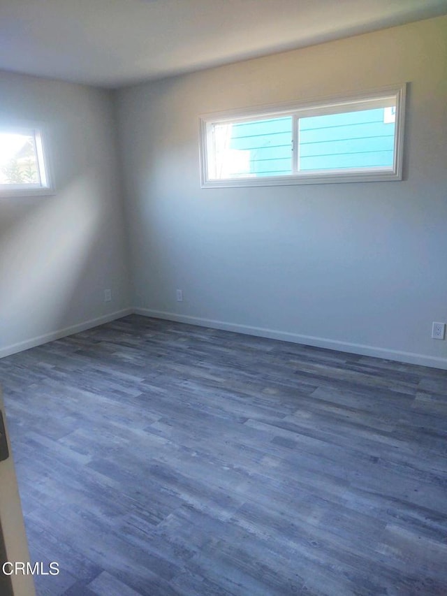 unfurnished room featuring a wealth of natural light and dark hardwood / wood-style flooring