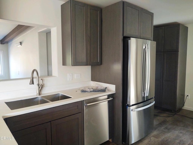 kitchen featuring dark wood-type flooring, appliances with stainless steel finishes, sink, and dark brown cabinetry