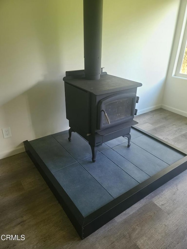 interior details with a wood stove and wood-type flooring