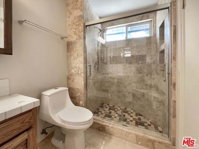 bathroom featuring tile patterned floors, vanity, toilet, and an enclosed shower