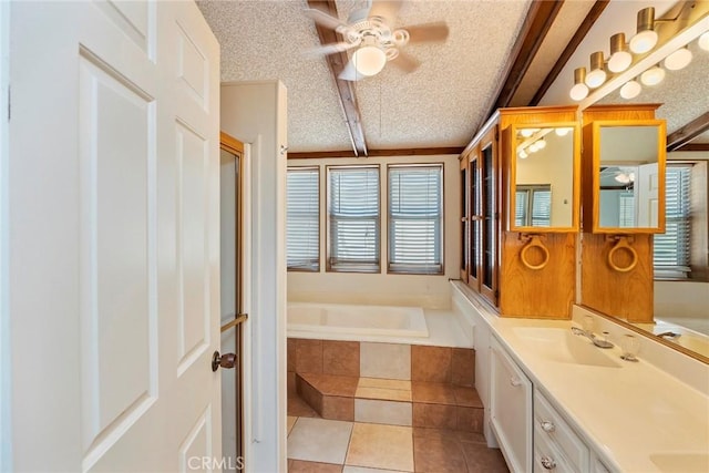 bathroom featuring vanity, tile patterned floors, a relaxing tiled tub, ceiling fan, and a textured ceiling