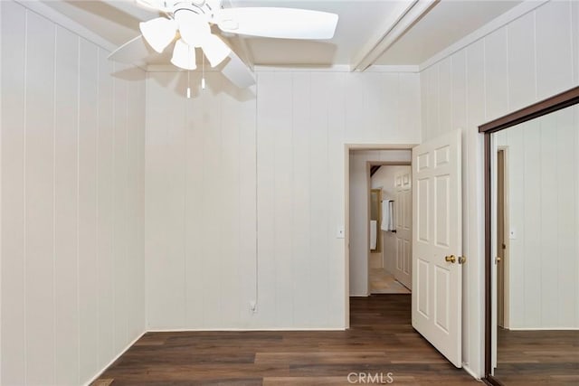 unfurnished room featuring wooden walls, dark hardwood / wood-style flooring, and ceiling fan