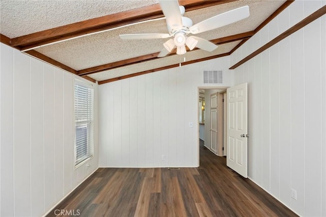 unfurnished room with wooden walls, dark hardwood / wood-style flooring, and a textured ceiling