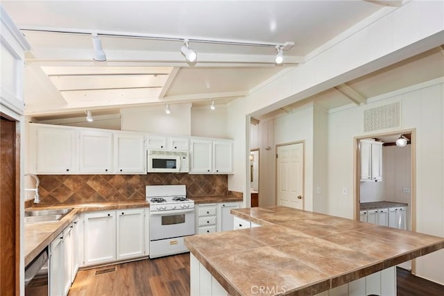 kitchen with sink, dark wood-type flooring, backsplash, white appliances, and white cabinets