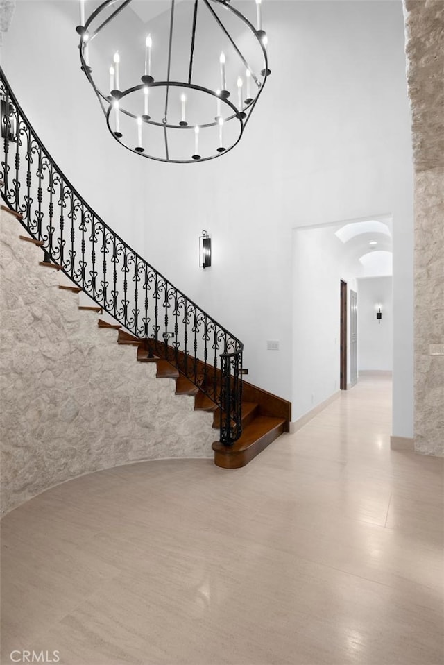 stairway with a notable chandelier and a high ceiling