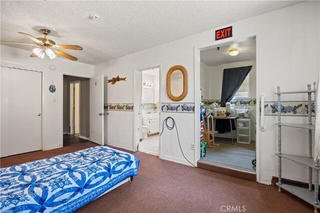 bedroom with a textured ceiling, connected bathroom, and ceiling fan