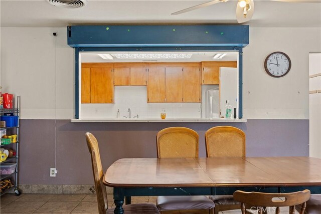 dining space with ceiling fan, sink, and light tile patterned floors