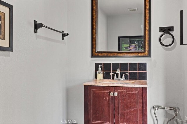 bathroom featuring decorative backsplash and vanity