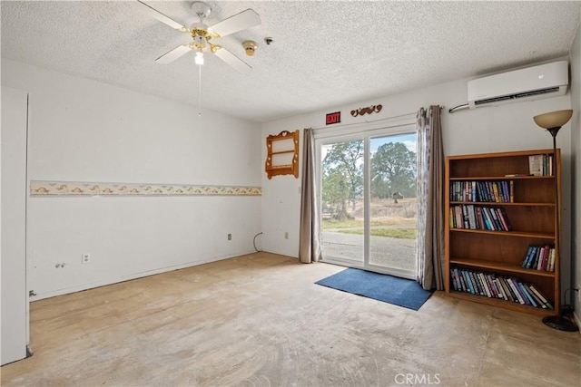 empty room with a textured ceiling, an AC wall unit, and ceiling fan