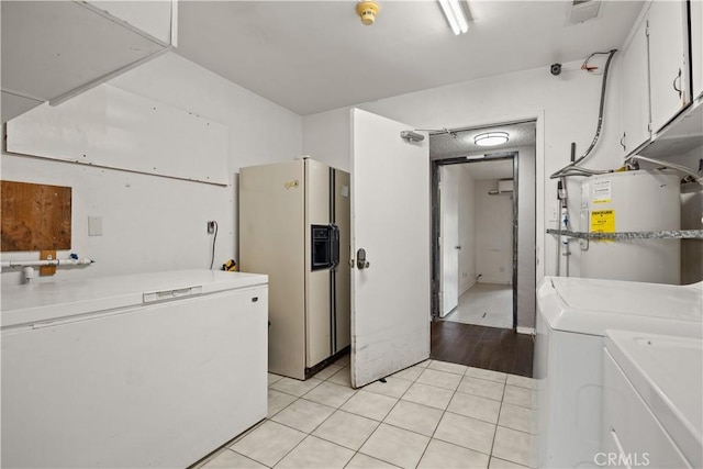 clothes washing area with cabinets, independent washer and dryer, light hardwood / wood-style flooring, and water heater