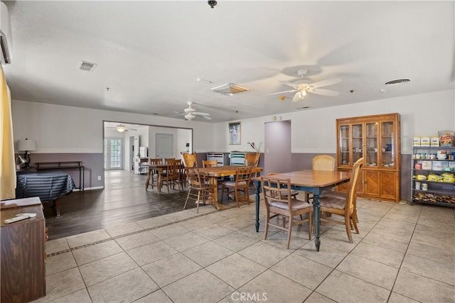 dining area with light wood-type flooring and ceiling fan