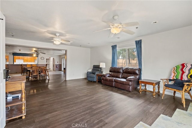 living room featuring ceiling fan and dark wood-type flooring