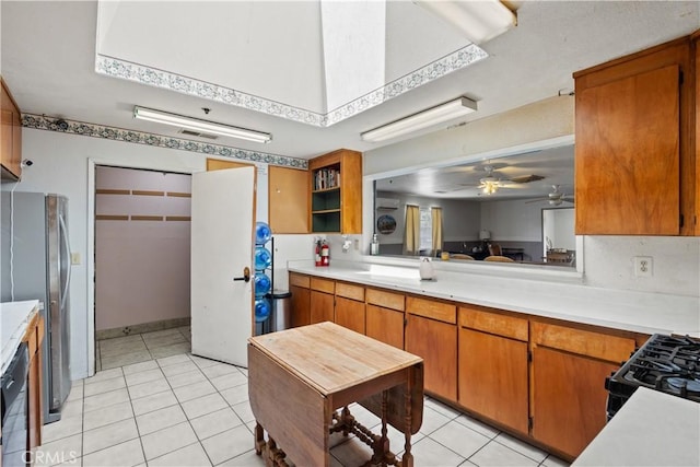 kitchen with light tile patterned floors, ceiling fan, and black appliances