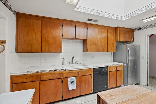 kitchen featuring stainless steel refrigerator, dishwasher, light tile patterned flooring, and sink