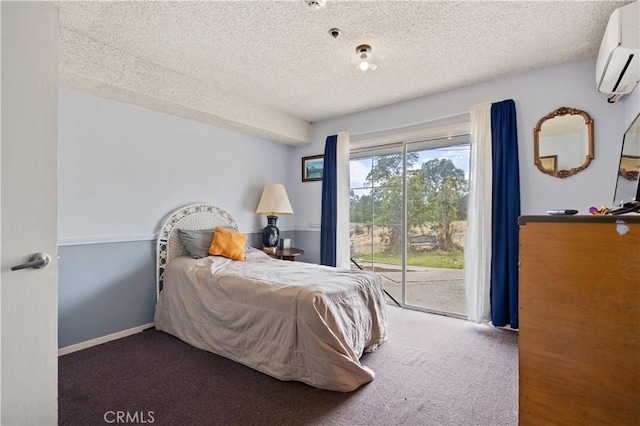 bedroom featuring access to outside, carpet floors, a wall unit AC, and a textured ceiling