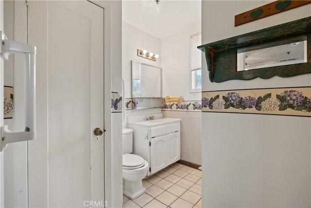 bathroom featuring tile patterned flooring, vanity, tile walls, and toilet