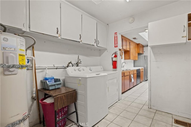 washroom featuring sink, cabinets, secured water heater, light tile patterned floors, and washer and dryer