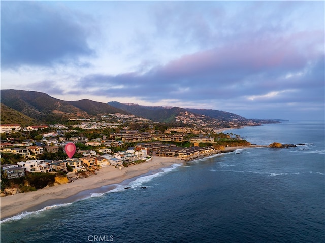 birds eye view of property with a water and mountain view and a view of the beach