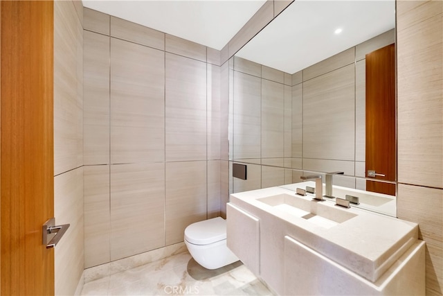 bathroom featuring vanity, toilet, tile patterned flooring, and tile walls