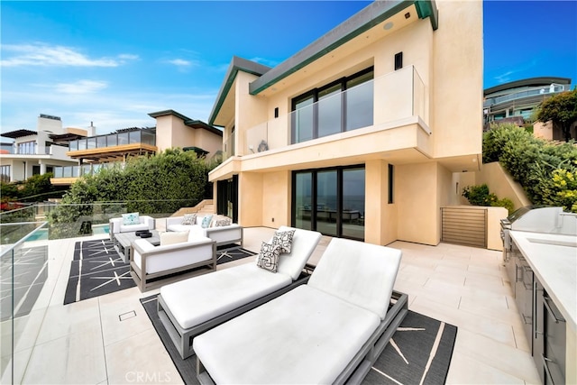 exterior space featuring a balcony, a patio area, and an outdoor hangout area