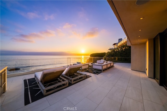 patio terrace at dusk featuring an outdoor hangout area and a water view