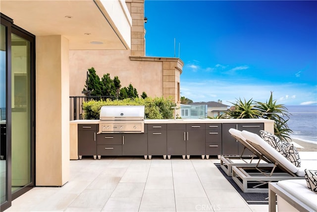 view of patio / terrace with a balcony, a water view, and grilling area