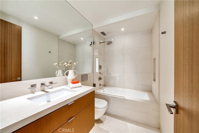 full bathroom with tile patterned flooring, toilet, tiled shower / bath combo, and vanity