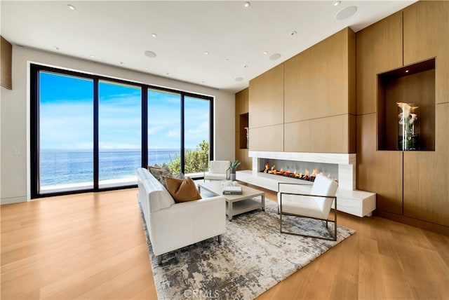 living room with light wood-type flooring and a water view