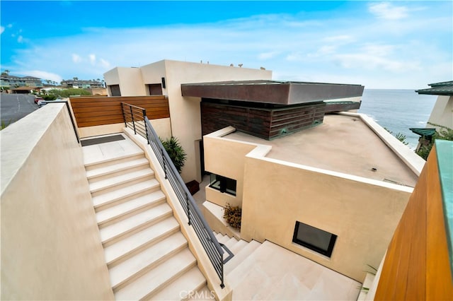 view of side of property featuring a balcony and a water view