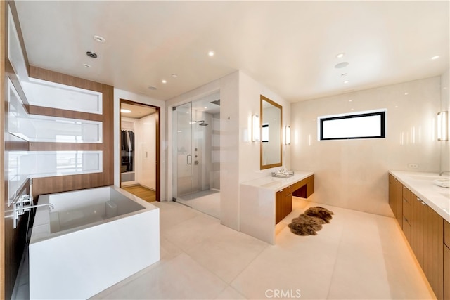 bathroom featuring tile patterned flooring, plus walk in shower, and vanity