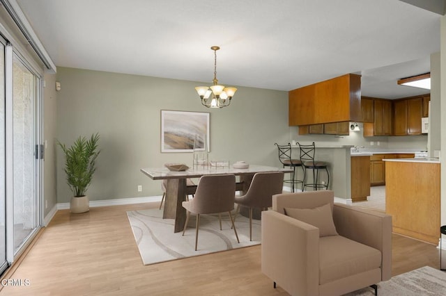 dining room featuring a notable chandelier and light hardwood / wood-style flooring