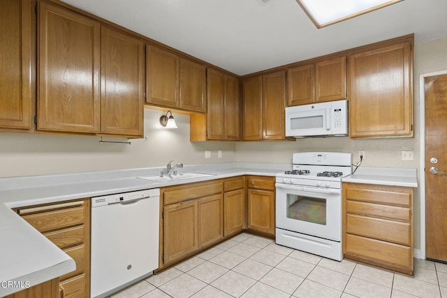 kitchen featuring sink, light tile patterned flooring, and white appliances