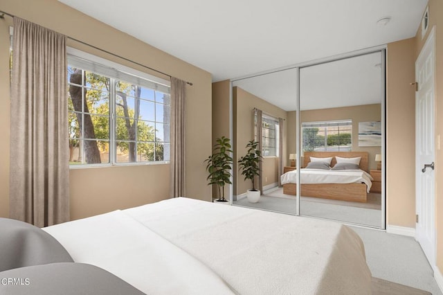 carpeted bedroom featuring multiple windows and a closet