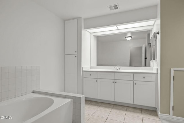 bathroom featuring tile patterned flooring, vanity, and a bath