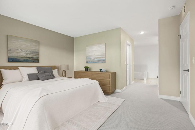 carpeted bedroom featuring ensuite bath