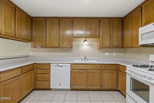 kitchen featuring light tile patterned flooring, white appliances, and sink