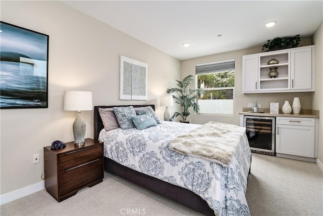 bedroom featuring light carpet, indoor bar, and beverage cooler