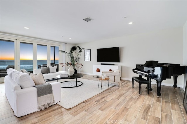 living room with plenty of natural light and light hardwood / wood-style flooring