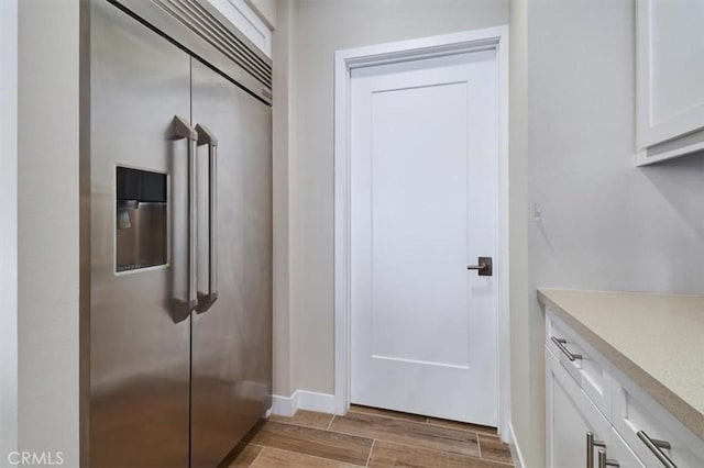 kitchen featuring white cabinetry and built in refrigerator