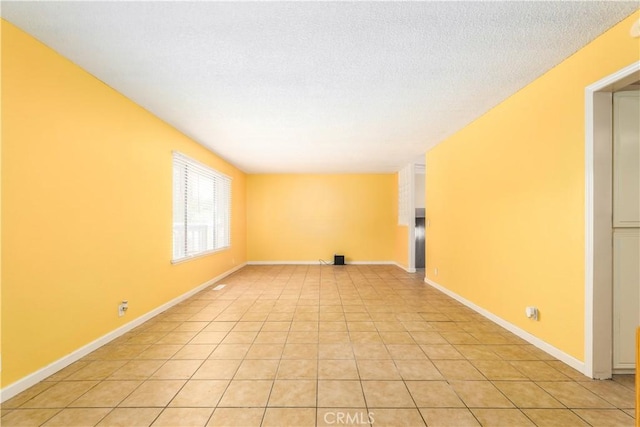 unfurnished room with light tile patterned flooring and a textured ceiling