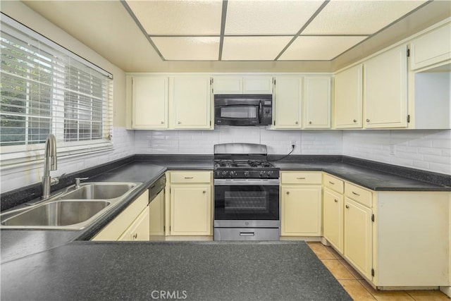 kitchen featuring cream cabinetry, light tile patterned floors, stainless steel appliances, and sink