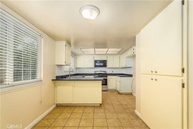 kitchen featuring sink, backsplash, white cabinetry, and stainless steel range with gas stovetop